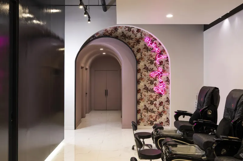 Arched hallway beside a neon-lit floral wall