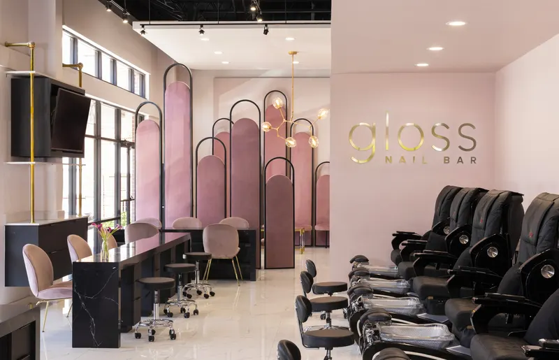 Gloss nail bar with signature wall logo and pedicure chairs