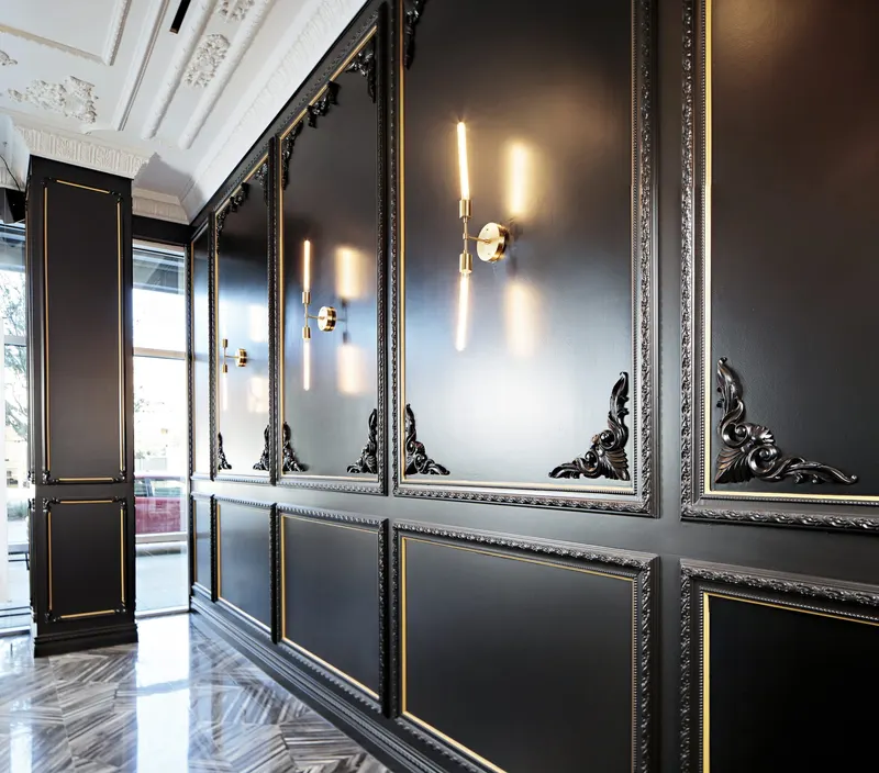 Paneled wall with gold inlay and sconces