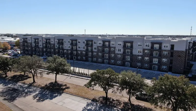 Four-story Richmond Estates buildings behind live oaks