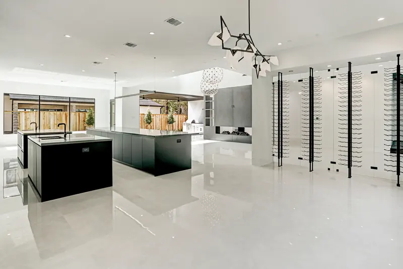Kitchen with two islands and a floor-to-ceiling glass wine display
