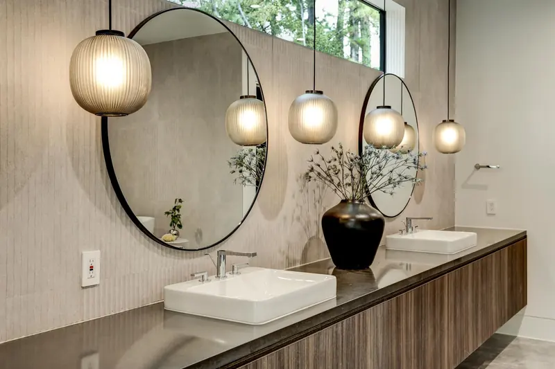 Floating double vanity with round mirrors and globe pendant lights