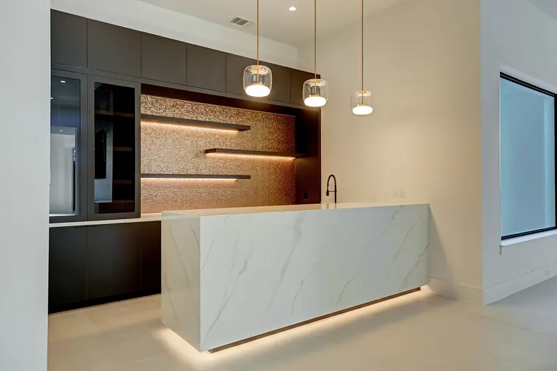 Backlit marble bar with walnut shelving and pendant lights