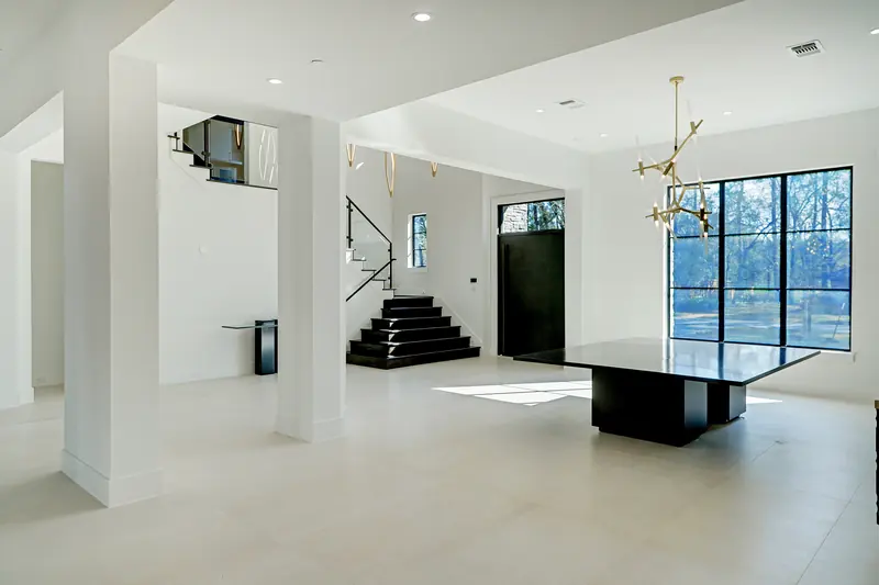 Entry and dining area with floating stair and black stone table