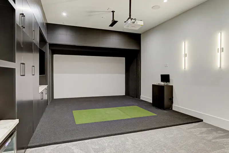 Golf simulator and media room with putting turf and projection screen