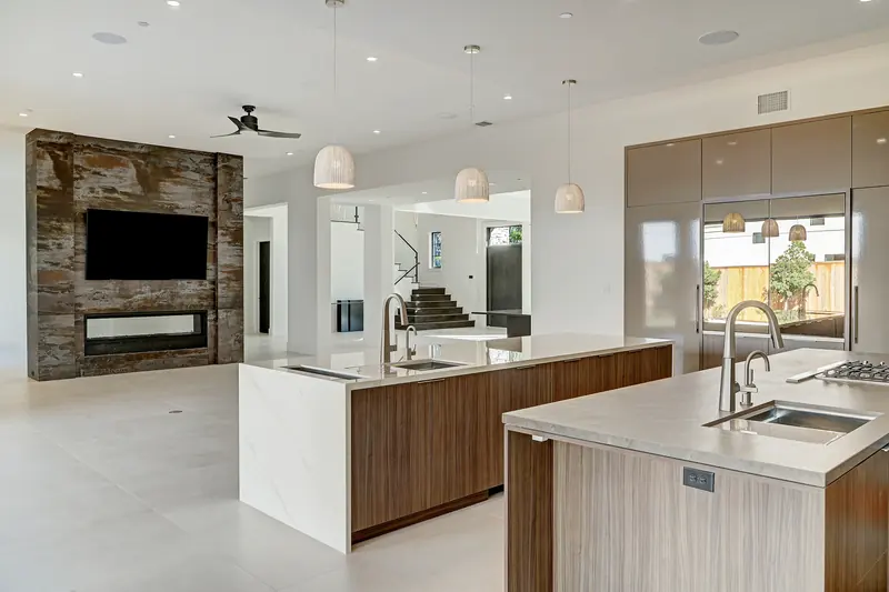 Kitchen islands and family room under a lit tray ceiling