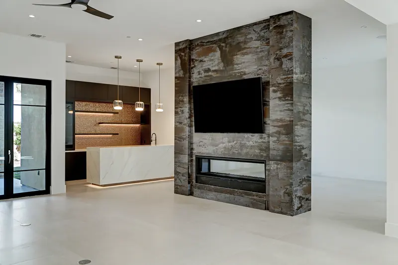 Living room with a stone-clad fireplace wall and view to the bar
