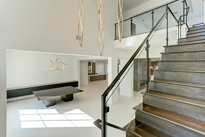 Wood-and-glass staircase with brass pendant lighting