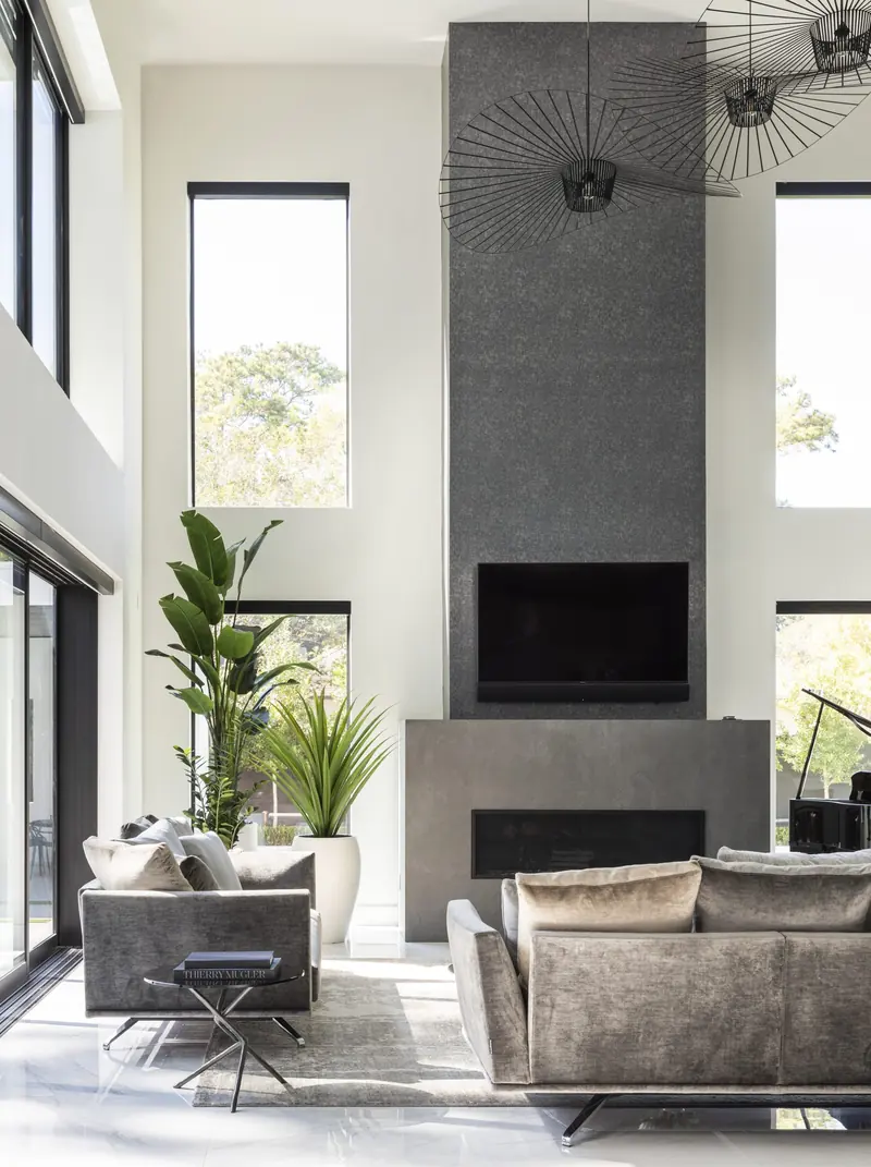 Living room fireplace tower framed by tall windows
