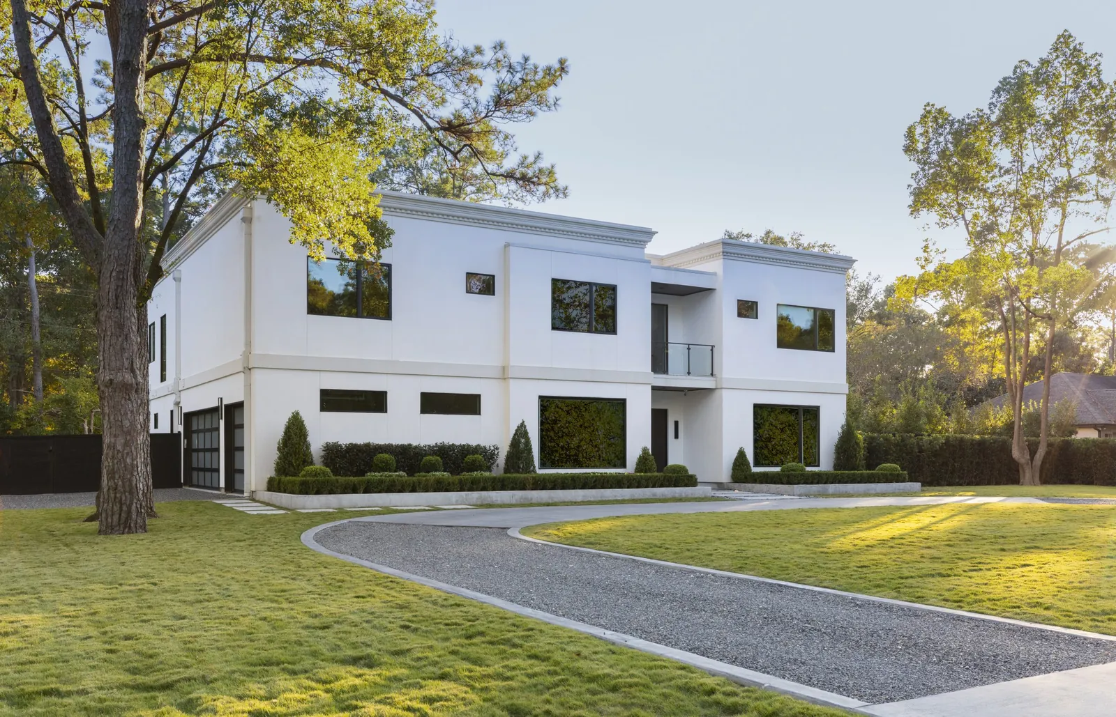 Front exterior of the Hedwig Village custom home with a long curved drive and mature trees