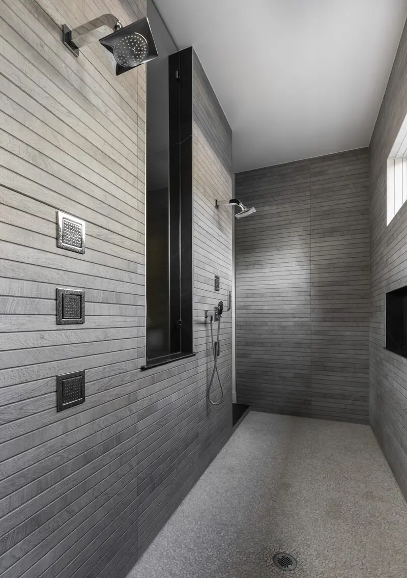 Walk-in shower with linear stone tile and rain head