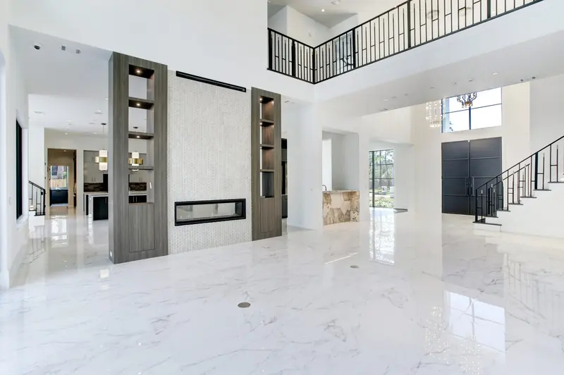 Double-height living room with a floating linear fireplace and an open catwalk above