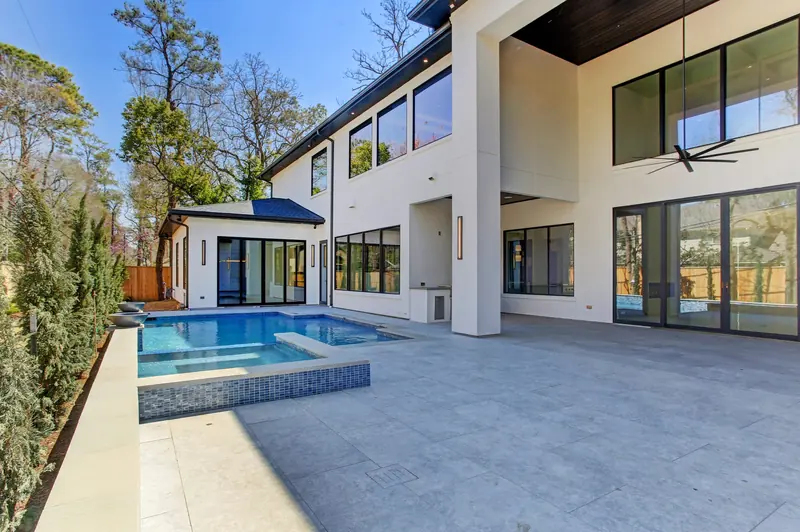Backyard pool and spa with a covered patio and pool house