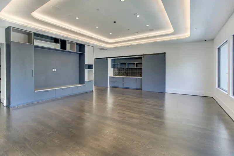 Second game room with a lit tray ceiling and built-in media wall