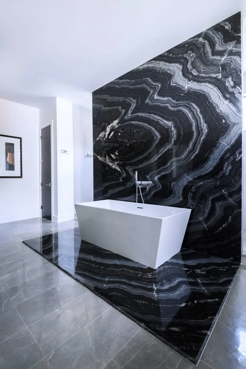 Bath with a freestanding tub against dramatic black marble
