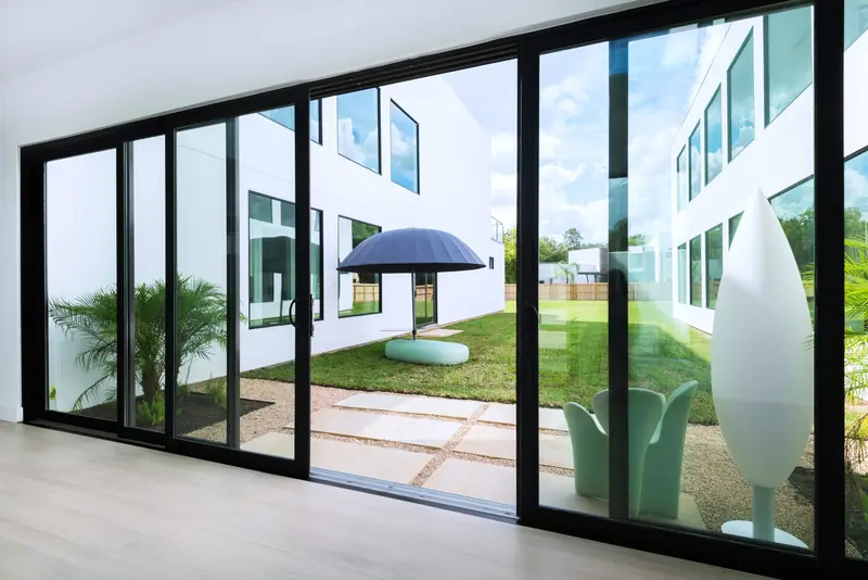 Sliding glass wall opening to a landscaped courtyard