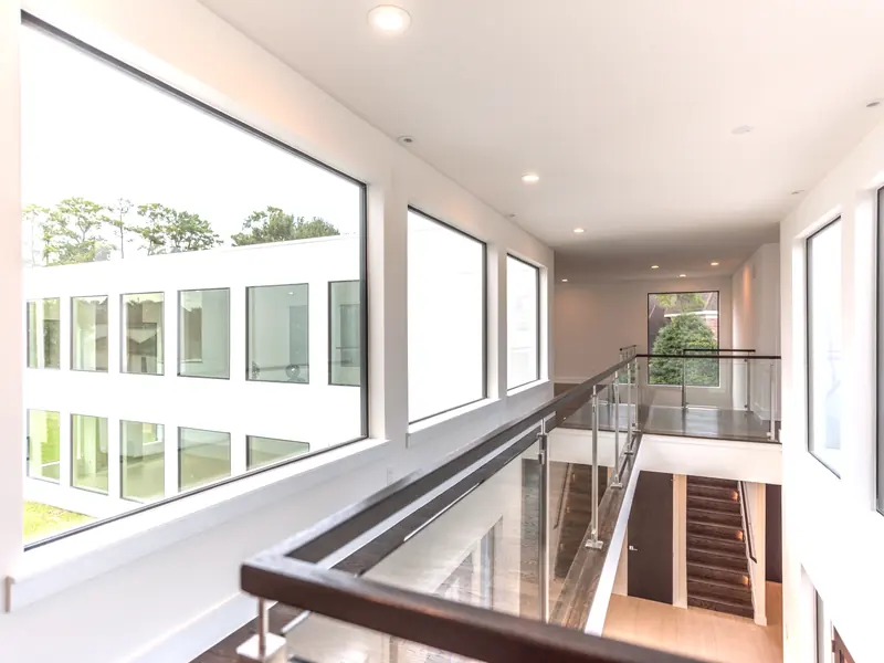 Second-floor bridge with glass railings overlooking the stair