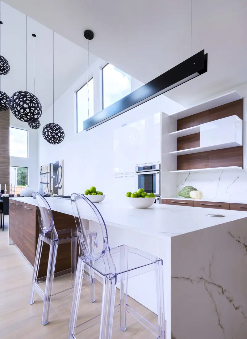 Kitchen with a marble waterfall island and acrylic stools