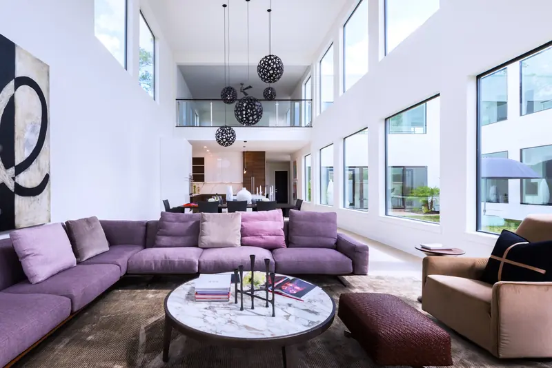 Living room with a sculptural sectional and double-height windows