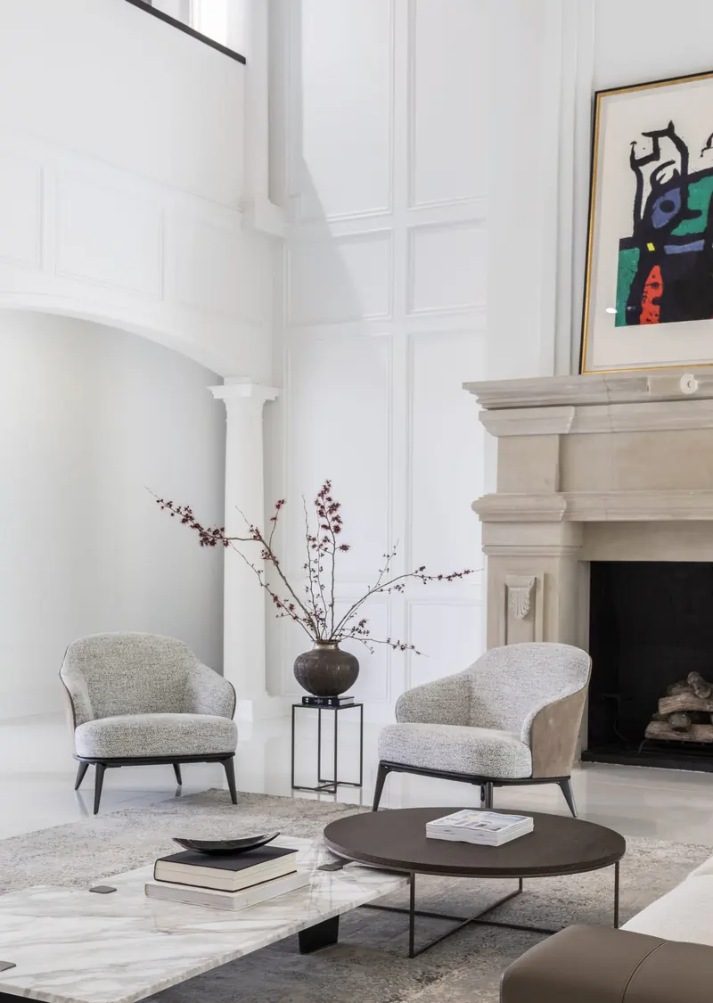 Fireplace sitting area beneath double-height paneled walls