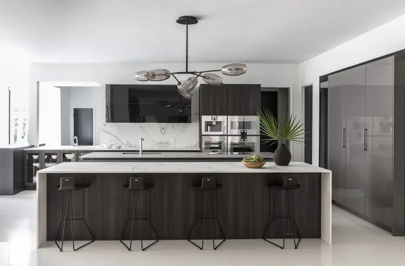 Kitchen with a wood-and-marble island and sculptural pendant
