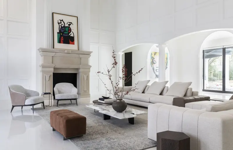 Living room with limestone fireplace, arched windows and contemporary art