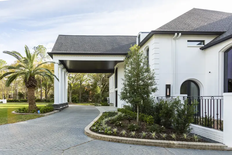 Motor court and porte-cochere with paver drive and palms