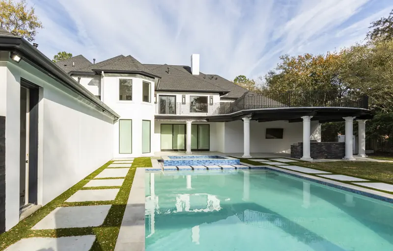 Rear exterior with a long swimming pool and grass-joint stone decking