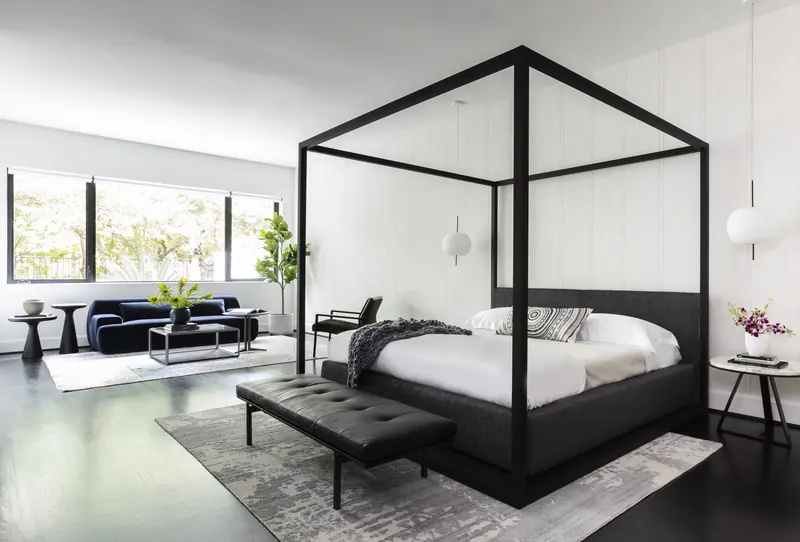 Primary bedroom with a black steel canopy bed