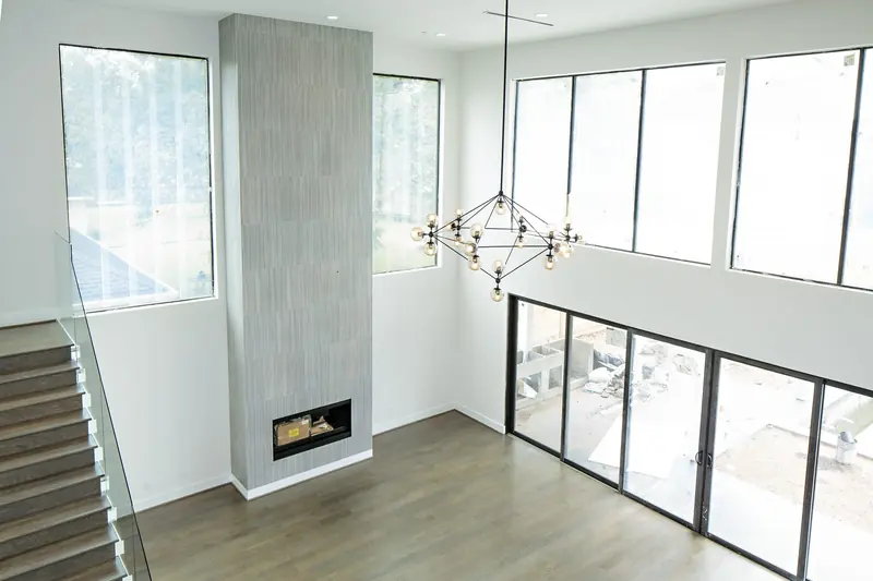 Fireplace column beside a wall of windows and sliding doors