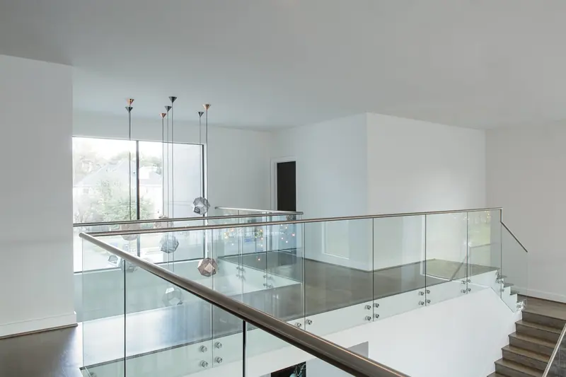 Second-floor landing with glass railings and pendant lights