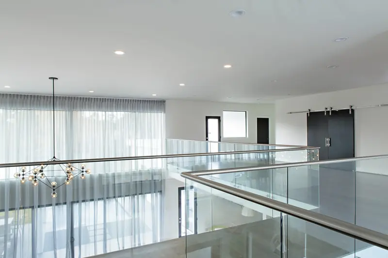 Upstairs loft with glass railing and barn door