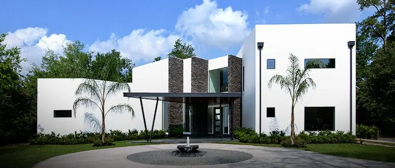 Modern white custom home with palms and circular motor court